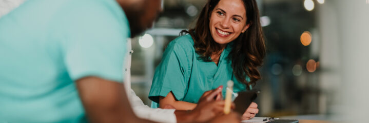 Healthcare professionals on night shift collaborating on medical records, smiling.