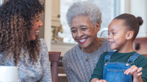 Young girl coloring with mom and grandma.