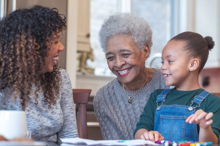 Young girl coloring with mom and grandma.